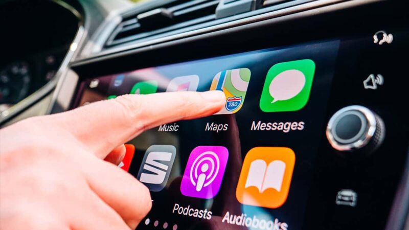 Pessoa tocando em painel de carro que tem Apple CarPlay